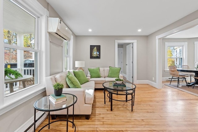 living room with light wood-type flooring and an AC wall unit