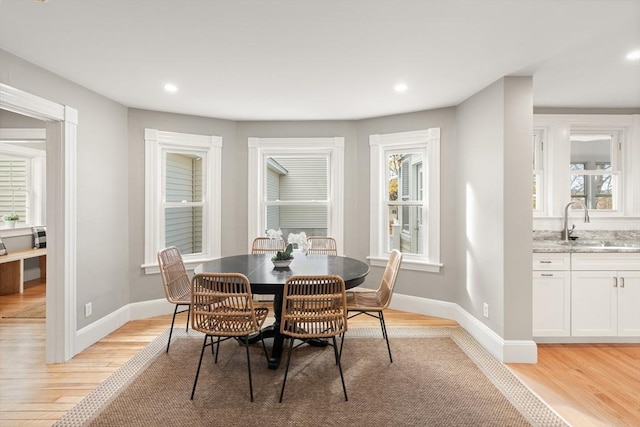 dining area with sink, light hardwood / wood-style flooring, and a healthy amount of sunlight