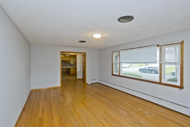 13 Louise Ave, Chicopee, MA 01013 - empty room featuring a baseboard radiator and light wood-style flooring