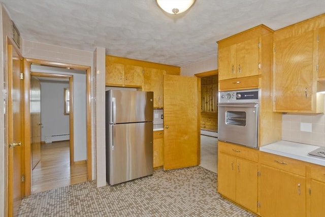13 Louise Ave, Chicopee, MA 01013 - kitchen featuring stainless steel appliances, baseboard heating, light countertops, tasteful backsplash, and light floors