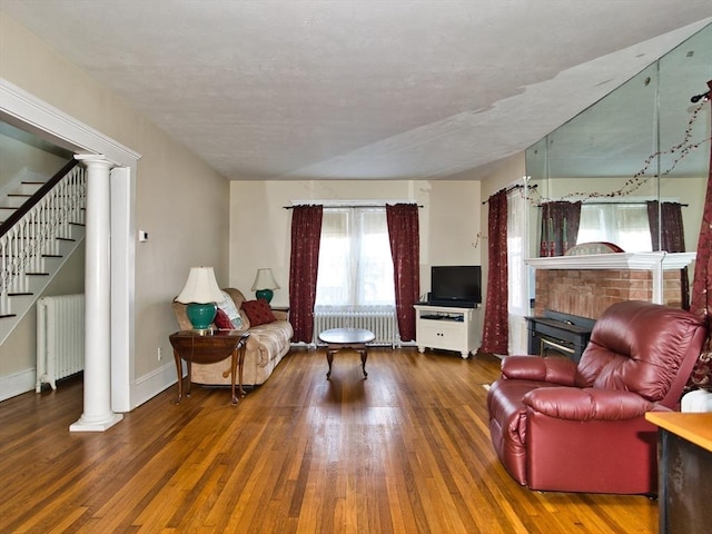 living room with radiator heating unit, dark wood-type flooring, and a textured ceiling