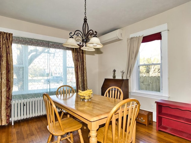 dining area with a notable chandelier, an AC wall unit, dark wood-type flooring, and radiator