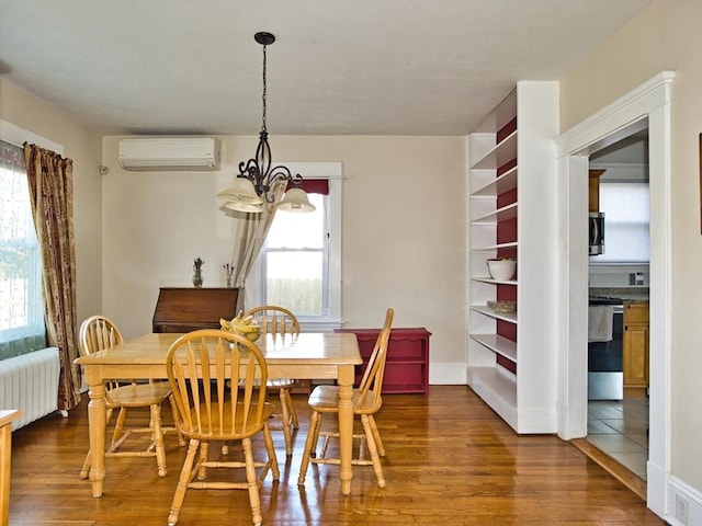 dining room with dark hardwood / wood-style flooring, an inviting chandelier, an AC wall unit, and radiator