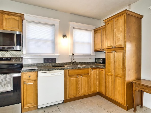 kitchen with appliances with stainless steel finishes, light tile patterned floors, and sink