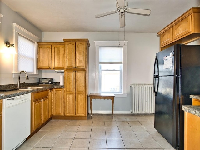 kitchen featuring radiator, ceiling fan, sink, black fridge, and white dishwasher