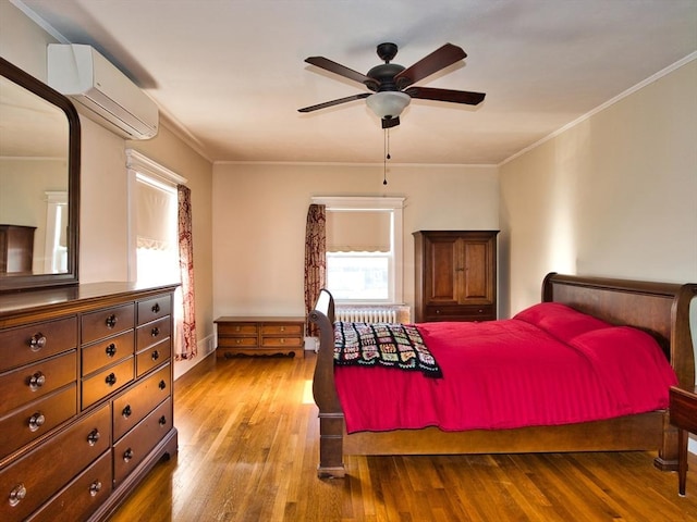 bedroom with ceiling fan, crown molding, light hardwood / wood-style flooring, an AC wall unit, and radiator heating unit