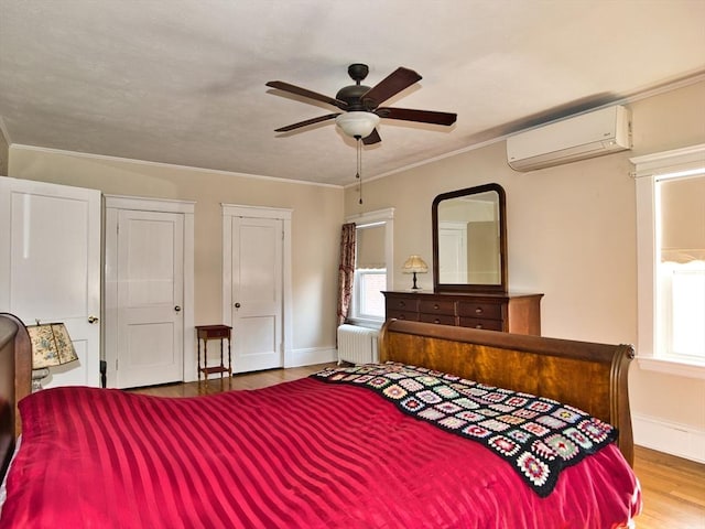 bedroom with multiple windows, radiator, a wall unit AC, and ceiling fan