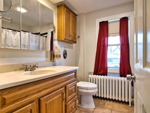 bathroom featuring radiator heating unit, vanity, toilet, and tile patterned floors