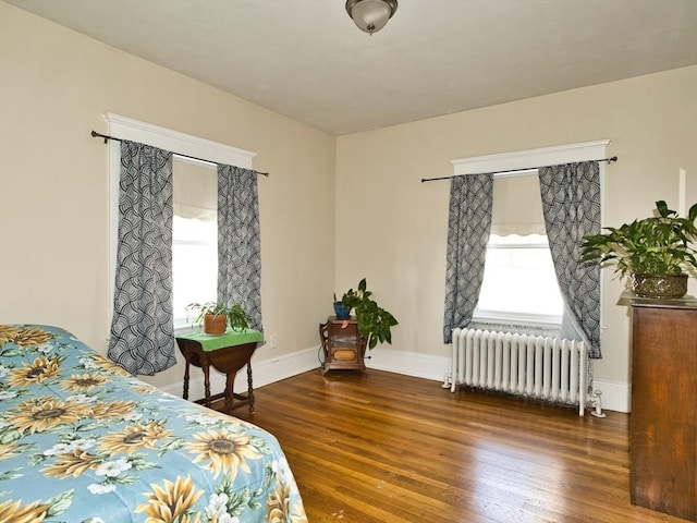 bedroom featuring radiator heating unit and dark hardwood / wood-style floors