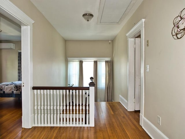 hallway with dark wood-type flooring and a wall unit AC