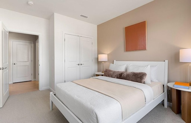 bedroom with light colored carpet and a closet