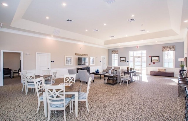 carpeted dining room featuring a raised ceiling