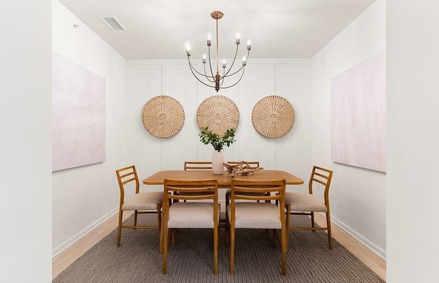 dining room featuring hardwood / wood-style floors and an inviting chandelier