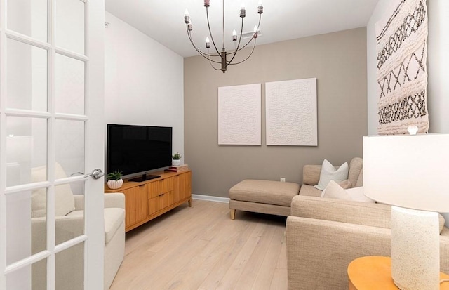 living room featuring light hardwood / wood-style floors and an inviting chandelier