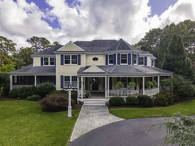 country-style home featuring a porch and a front yard