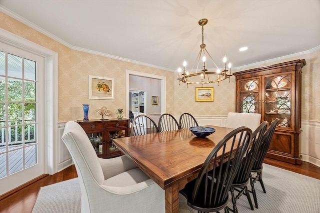 dining room with hardwood / wood-style floors, a notable chandelier, and crown molding