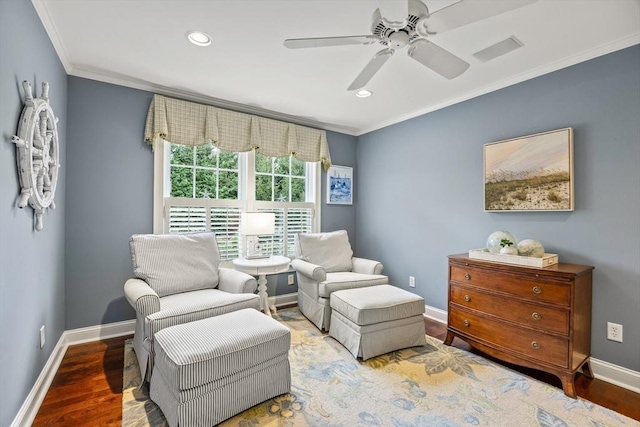 sitting room featuring hardwood / wood-style flooring, ceiling fan, and crown molding