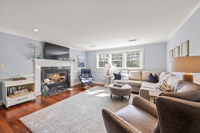 living room featuring a high end fireplace, dark hardwood / wood-style floors, and crown molding