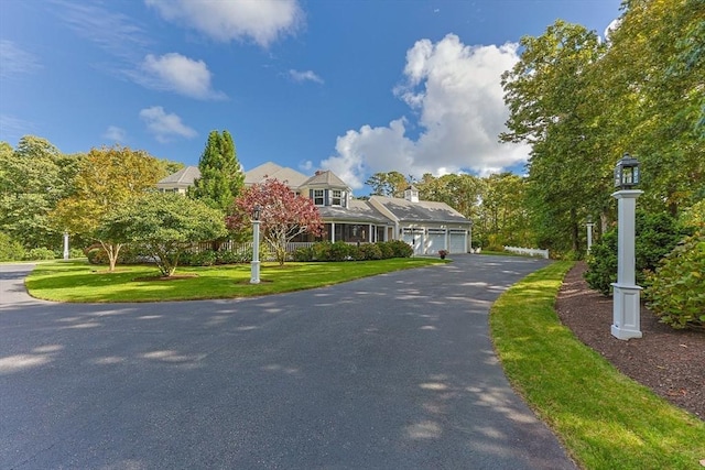 new england style home featuring a garage and a front yard