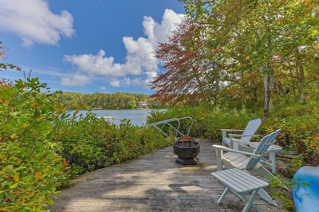 view of patio with a deck with water view and a fire pit