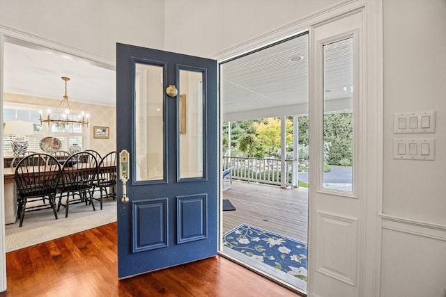 doorway to outside with dark hardwood / wood-style floors and an inviting chandelier