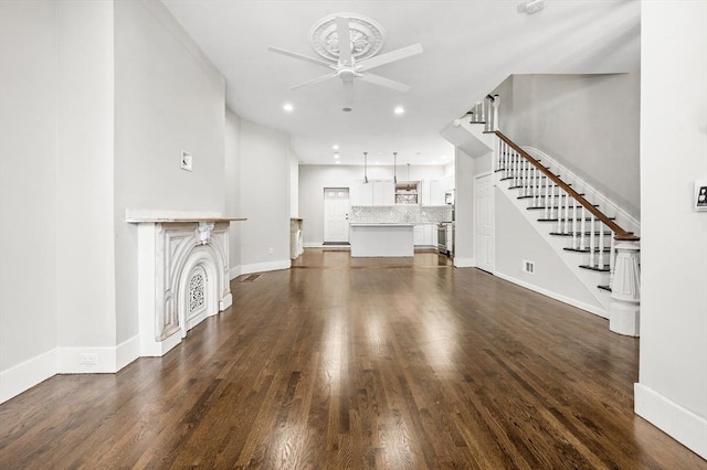 unfurnished living room with ceiling fan and dark hardwood / wood-style floors