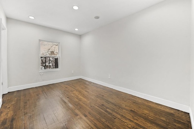 unfurnished room with dark wood-type flooring