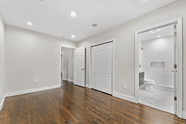 unfurnished bedroom featuring dark hardwood / wood-style floors and ensuite bathroom