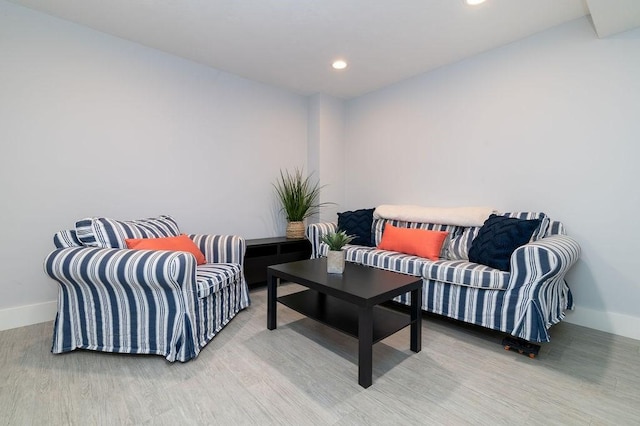 living room featuring recessed lighting, baseboards, and light wood finished floors