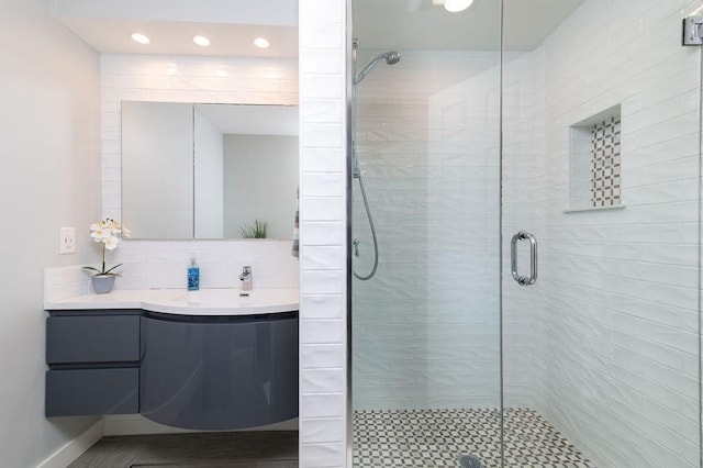 bathroom with vanity, decorative backsplash, and a stall shower