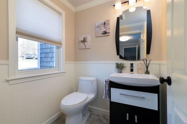 bathroom featuring vanity, ornamental molding, wainscoting, and toilet