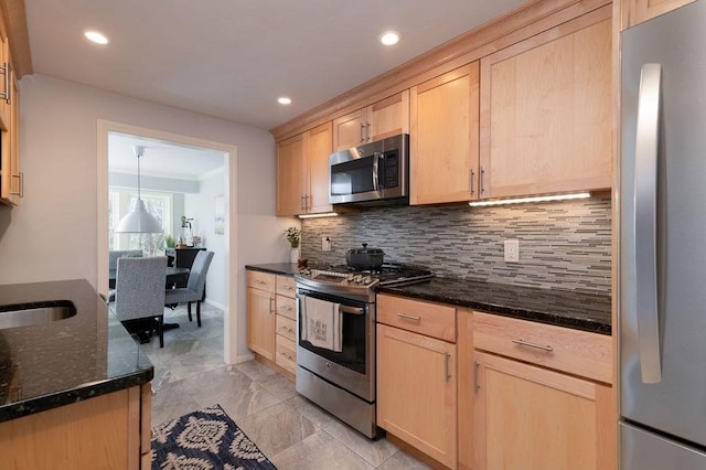 kitchen with light brown cabinetry, appliances with stainless steel finishes, dark stone counters, and tasteful backsplash