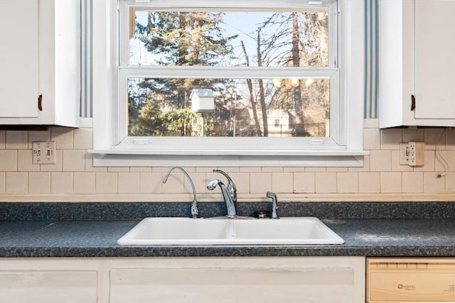 interior space with white cabinets, dishwasher, backsplash, and sink