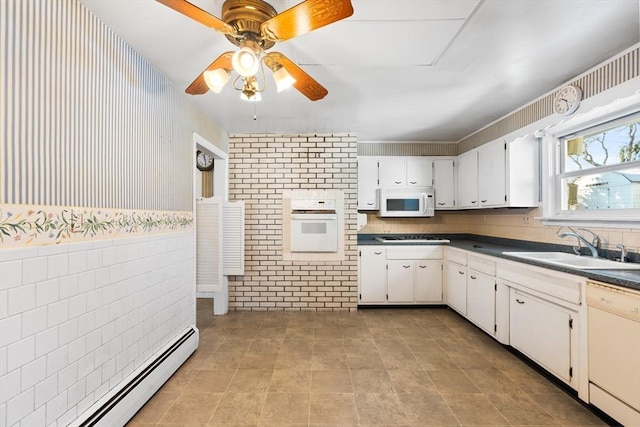 kitchen with white appliances, baseboard heating, white cabinetry, ceiling fan, and sink