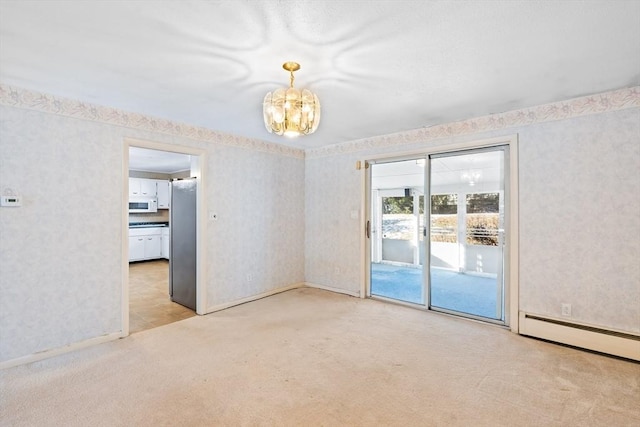 carpeted spare room with baseboard heating and an inviting chandelier