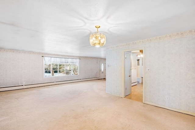 carpeted spare room with ceiling fan with notable chandelier and a baseboard heating unit