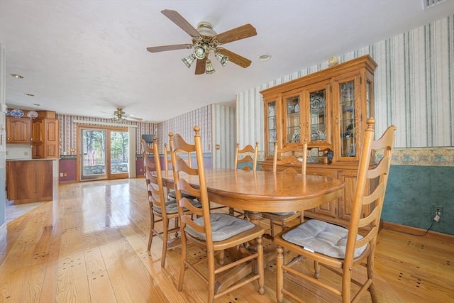 dining room featuring wallpapered walls, a ceiling fan, light wood-type flooring, and baseboards