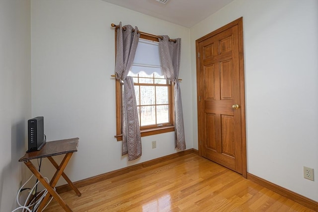 unfurnished room featuring light wood-style flooring and baseboards