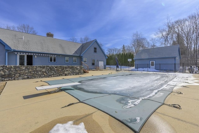 view of swimming pool with a diving board, a patio, an outbuilding, and fence