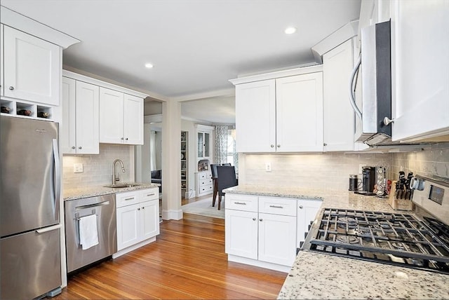 8 Cambridge Ter Unit 2, Cambridge, MA 02140 - kitchen with stainless steel appliances, decorative backsplash, white cabinets, a sink, and recessed lighting