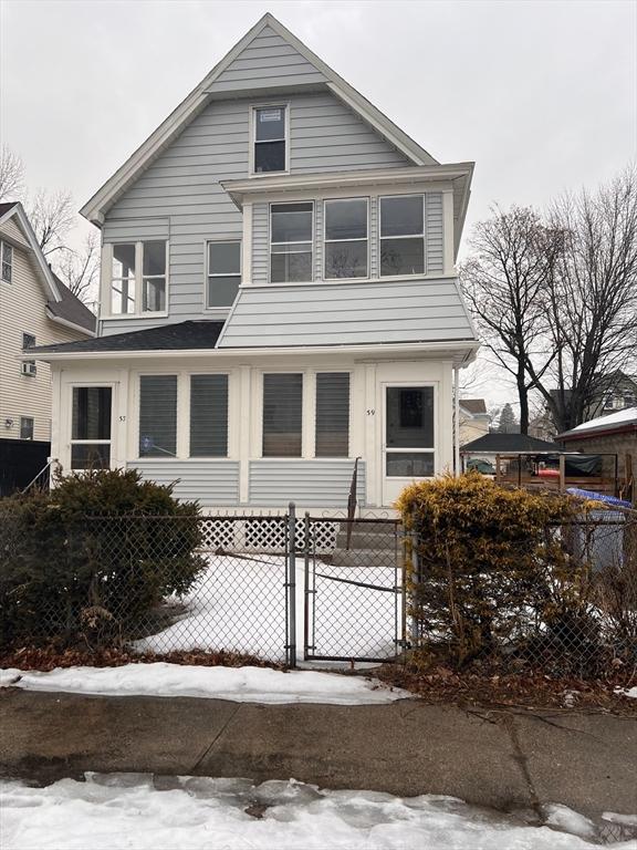 american foursquare style home with a fenced front yard and a gate