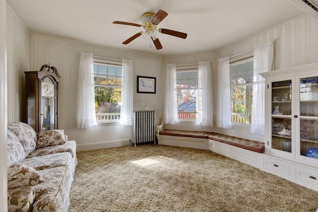 unfurnished room featuring carpet floors, crown molding, radiator heating unit, and a ceiling fan