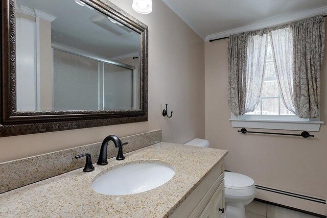 bathroom with toilet, a baseboard heating unit, vanity, a stall shower, and crown molding