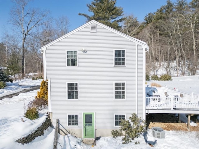 view of snow covered exterior with cooling unit and a wooden deck