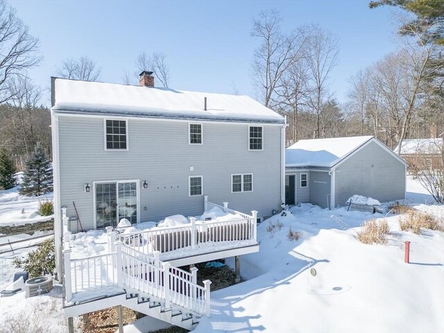 snow covered rear of property featuring a chimney, a deck, and central AC unit