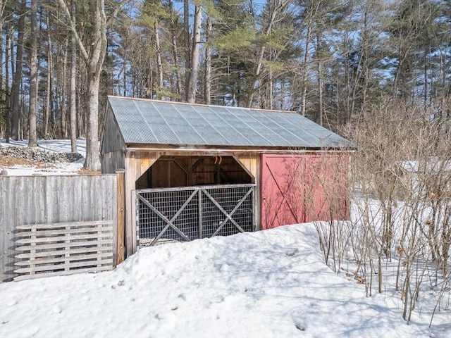 snow covered structure with an outbuilding