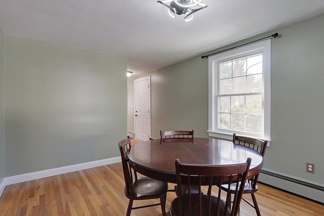 dining area featuring light wood-style floors, baseboards, and baseboard heating