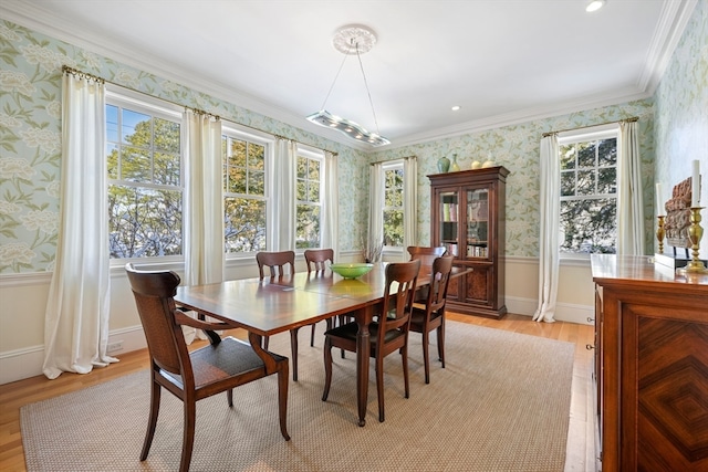 dining area with ornamental molding and light wood-type flooring