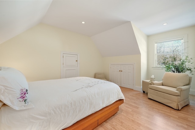 bedroom featuring a closet, vaulted ceiling, and light wood-type flooring