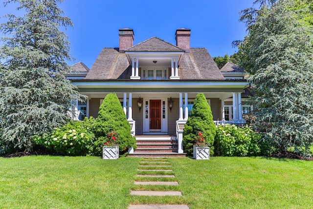 view of front of home with a front yard and a porch